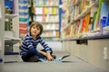 Adorable little child, boy, sitting in a book store Royalty Free Stock Photo