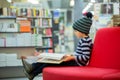 Adorable little child, boy, sitting in a book store Royalty Free Stock Photo