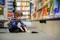 Adorable little child, boy, sitting in a book store Royalty Free Stock Photo