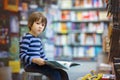 Adorable little child, boy, sitting in a book store Royalty Free Stock Photo