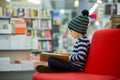 Adorable little child, boy, sitting in a book store Royalty Free Stock Photo