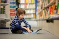 Adorable little child, boy, sitting in a book store Royalty Free Stock Photo