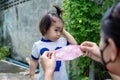 Adorable little child girl with big capillary strawberry hemangiomas red birthmark on head refuses to wear medical face mask