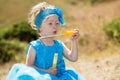 Adorable little child girl with bubble blower on grass on meadow. Summer green nature . Royalty Free Stock Photo