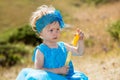 Adorable little child girl with bubble blower on grass on meadow. Summer green nature . Royalty Free Stock Photo