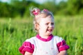 Adorable little child girl cry on grass on meadow. Royalty Free Stock Photo