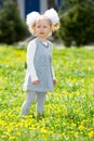 Adorable little child girl on grass on meadow. Summer green nature background. Royalty Free Stock Photo