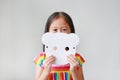 Adorable little child girl holding blank white animal paper mask fronting her face on white background. Idea and concept for kid