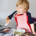 Adorable little child helping and baking apple pie in home's kitchen Royalty Free Stock Photo