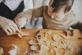 Adorable little daughter with mother making together christmas gingerbread cookies on messy wooden table. Cute toddler girl helps Royalty Free Stock Photo