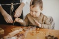 Adorable little daughter and mother making together gingerbread cookies on messy wooden table in modern room. Cute toddler girl Royalty Free Stock Photo