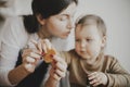 Adorable little daughter and mother making together gingerbread cookies on messy wooden table in modern room. Cute toddler girl Royalty Free Stock Photo