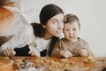 Adorable little daughter and mother making together gingerbread cookies on messy wooden table in modern room. Cute toddler girl Royalty Free Stock Photo