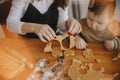 Adorable little daughter and mother making together gingerbread cookies on messy wooden table in modern room. Cute toddler girl Royalty Free Stock Photo