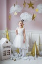Adorable little fairy girl with magic wand at christmas decorations indoors