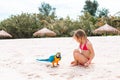 Adorable little girl at beach with colorful parrot Royalty Free Stock Photo