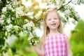 Adorable little girl in blooming apple tree garden on beautiful spring day Royalty Free Stock Photo