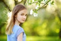 Adorable little girl in blooming apple tree garden on beautiful spring day Royalty Free Stock Photo