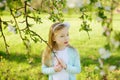 Adorable little girl in blooming apple tree garden on beautiful spring day. Cute child picking apple tree flowers at spring Royalty Free Stock Photo