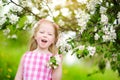 Adorable little girl in blooming apple tree garden on beautiful spring day Royalty Free Stock Photo