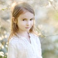 Adorable little girl in blooming cherry garden Royalty Free Stock Photo