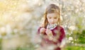 Adorable little girl in blooming cherry tree garden on beautiful spring day Royalty Free Stock Photo