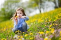 Adorable little girl in blooming dandelion flowers Royalty Free Stock Photo