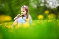 Adorable little girl in blooming dandelion meadow on beautiful spring day Royalty Free Stock Photo