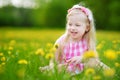 Adorable little girl in blooming dandelion meadow on beautiful spring day Royalty Free Stock Photo