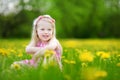 Adorable little girl in blooming dandelion meadow on beautiful spring day Royalty Free Stock Photo