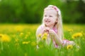 Adorable little girl in blooming dandelion meadow on beautiful spring day Royalty Free Stock Photo