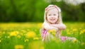 Adorable little girl in blooming dandelion meadow on beautiful spring day Royalty Free Stock Photo