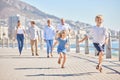 Adorable little girl and boy running ahead on a seaside promenade on a sunny day. Multi-generation family with two kids Royalty Free Stock Photo