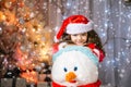 Adorable little girl building a snowman in beautiful winter park. Cute child playing in a snow. Winter activities for Royalty Free Stock Photo