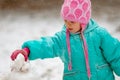 Close-up portrait of Adorable little girl building a snowman on a snowy winter day. Royalty Free Stock Photo