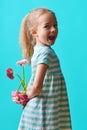 Adorable little girl with cheeky smile and face expression holding bouquet of pink gerbera daisies. Happy Mother`s Day. Royalty Free Stock Photo