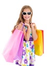 Adorable little girl child in sunglasses holding shopping colorful paper bags Royalty Free Stock Photo