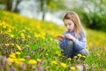 Adorable little girl in dandelion flowers Royalty Free Stock Photo