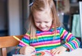 Adorable little girl draws paints sitting at the Royalty Free Stock Photo
