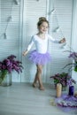 Adorable little girl dressed as a ballerina in a tutu, tying her ballet slippers. Royalty Free Stock Photo