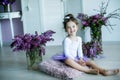 Adorable little girl dressed as a ballerina in a tutu, tying her ballet slippers. Royalty Free Stock Photo