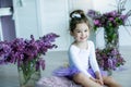 Adorable little girl dressed as a ballerina in a tutu, tying her ballet slippers. Royalty Free Stock Photo