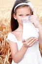 Adorable little girl drinking milk on field of wheat Royalty Free Stock Photo