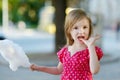 Adorable little girl eating candy-floss outdoors Royalty Free Stock Photo