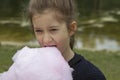 Adorable little girl eating candy-floss outdoors at summer