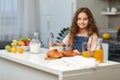 Adorable little girl, eating cereals healthy breakfast on the kitchen, looking at the camera with spoon in her hand. Royalty Free Stock Photo