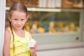 Adorable little girl eating ice-cream outdoors at summer. Cute kid enjoying real italian gelato near Gelateria in Rome Royalty Free Stock Photo