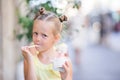 Adorable little girl eating ice-cream outdoors at summer. Cute kid enjoying real italian gelato near Gelateria in Rome Royalty Free Stock Photo