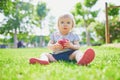 Adorable little girl eating red apple outdoors in park on a sunny day Royalty Free Stock Photo