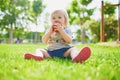 Adorable little girl eating red apple outdoors in park on a sunny day Royalty Free Stock Photo